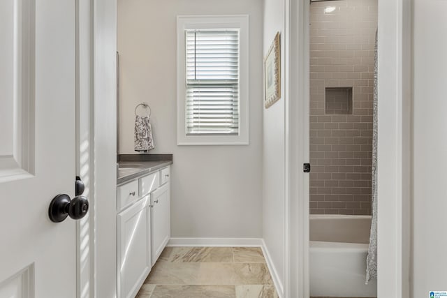 bathroom featuring tiled shower / bath combo and vanity