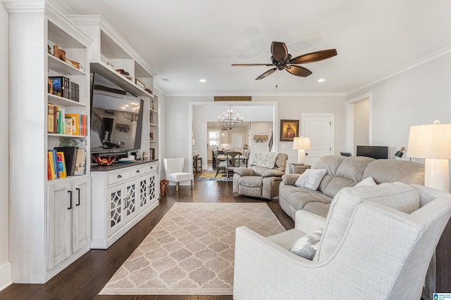 living room with dark hardwood / wood-style floors, built in features, crown molding, and ceiling fan with notable chandelier