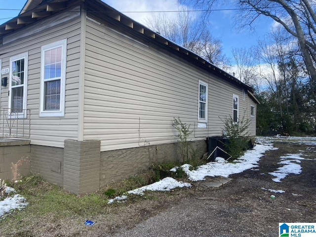 view of snow covered exterior with central AC unit