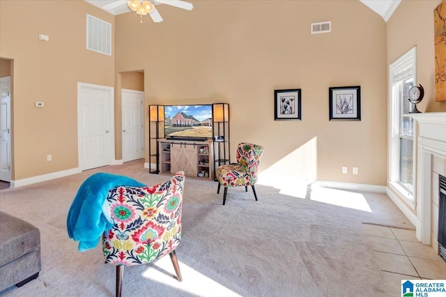 carpeted living room with ceiling fan, high vaulted ceiling, and a fireplace