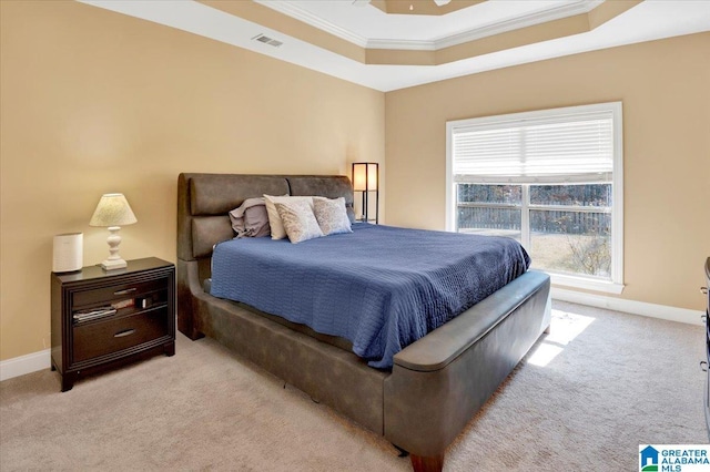 bedroom with light carpet, a tray ceiling, and crown molding