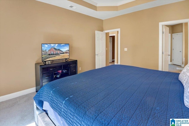 bedroom featuring light colored carpet, a tray ceiling, and crown molding