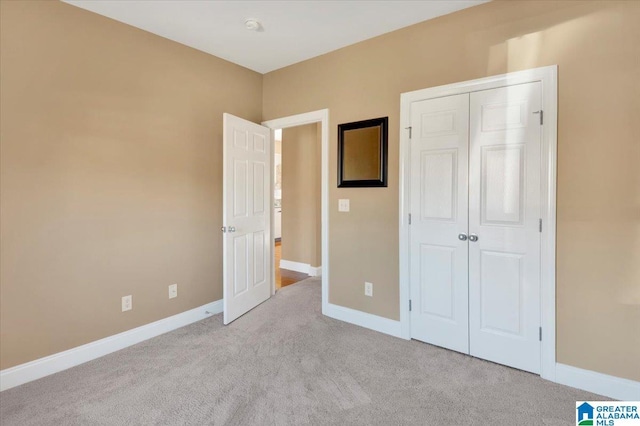 unfurnished bedroom featuring light colored carpet and a closet