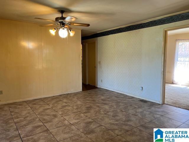 unfurnished room featuring ceiling fan and crown molding