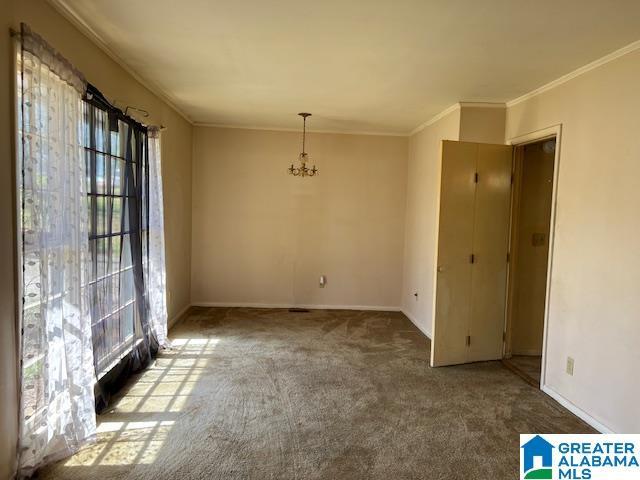 unfurnished dining area with a chandelier, carpet flooring, and crown molding