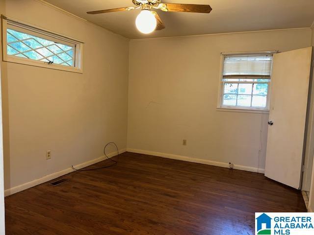 spare room featuring ceiling fan and dark wood-type flooring