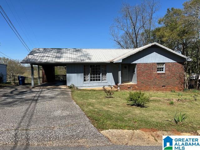 single story home featuring a front yard and a carport