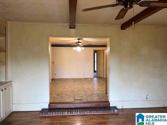 spare room featuring beamed ceiling, ceiling fan, and light hardwood / wood-style flooring