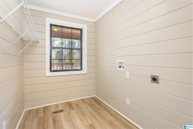 clothes washing area with hardwood / wood-style floors, wood walls, crown molding, washer hookup, and hookup for an electric dryer