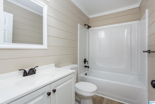 full bathroom with washtub / shower combination, vanity, toilet, and wood walls