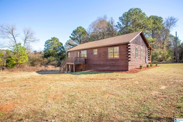 view of side of property featuring a lawn and a deck