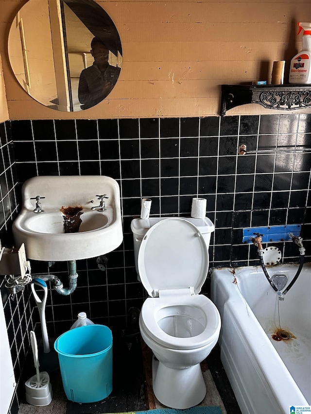 bathroom with sink, toilet, a bathing tub, and tile walls