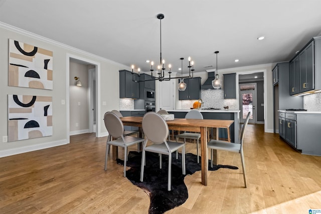 dining area with a notable chandelier, crown molding, and light hardwood / wood-style flooring