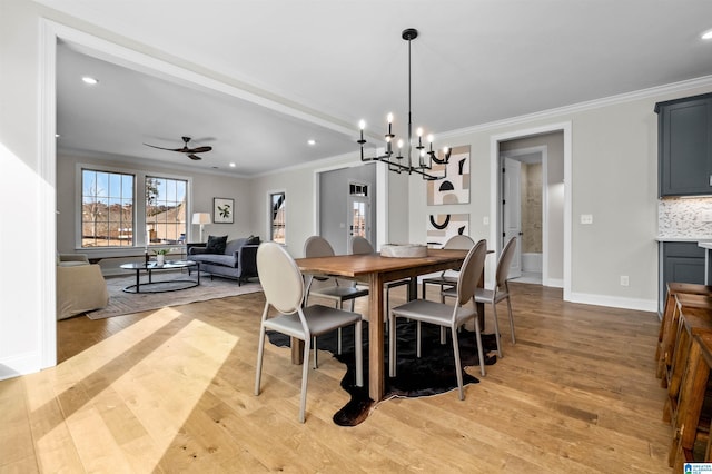 dining space featuring ceiling fan with notable chandelier, light hardwood / wood-style floors, and crown molding