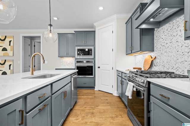 kitchen with decorative backsplash, custom exhaust hood, stainless steel appliances, sink, and hanging light fixtures