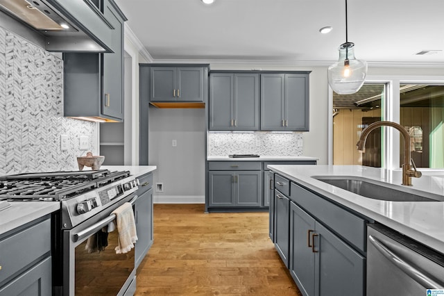 kitchen with premium range hood, sink, hanging light fixtures, ornamental molding, and stainless steel appliances