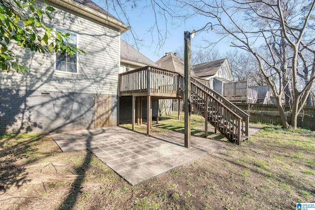 rear view of house with a patio, a wooden deck, and a lawn