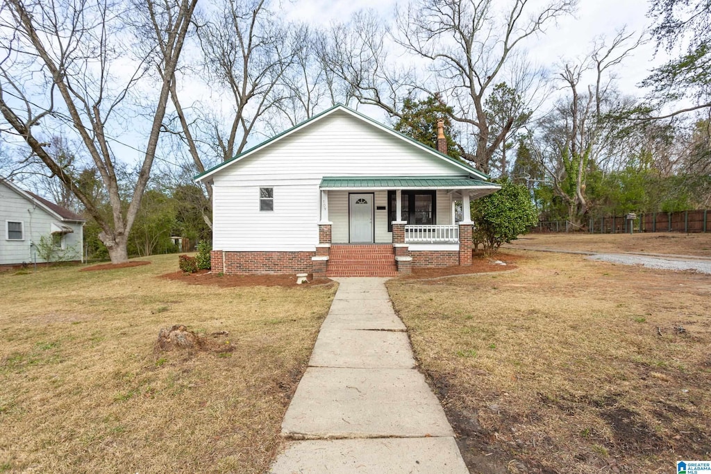 bungalow featuring a front lawn and covered porch