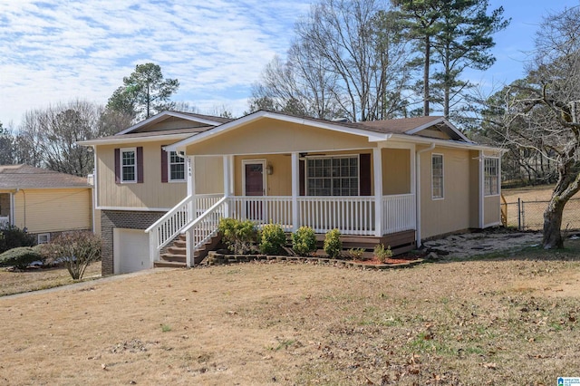 view of front of home featuring a front lawn, a porch, and a garage