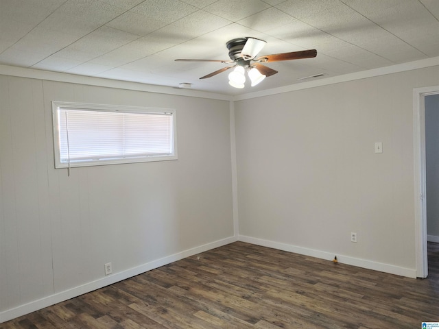 empty room with ceiling fan, dark hardwood / wood-style flooring, and crown molding