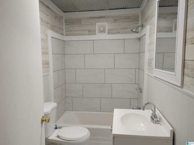 full bathroom with tiled shower / bath, vanity, and toilet