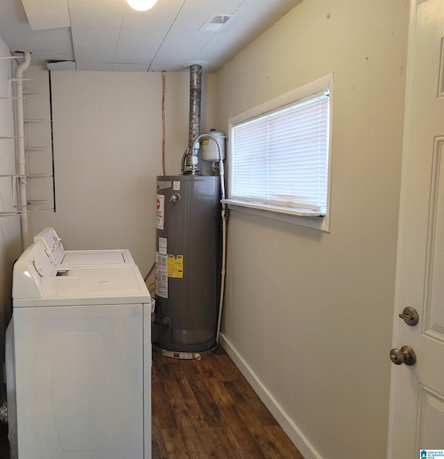 clothes washing area featuring water heater, washer and dryer, and dark hardwood / wood-style floors