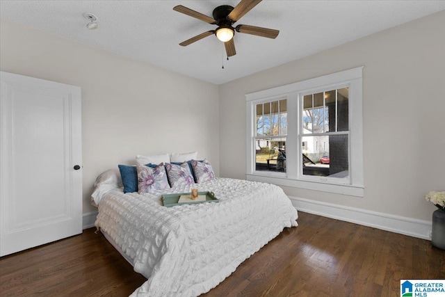 bedroom featuring a textured ceiling, ceiling fan, and dark hardwood / wood-style flooring