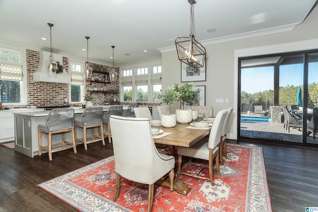 dining area featuring dark hardwood / wood-style flooring, a healthy amount of sunlight, and crown molding