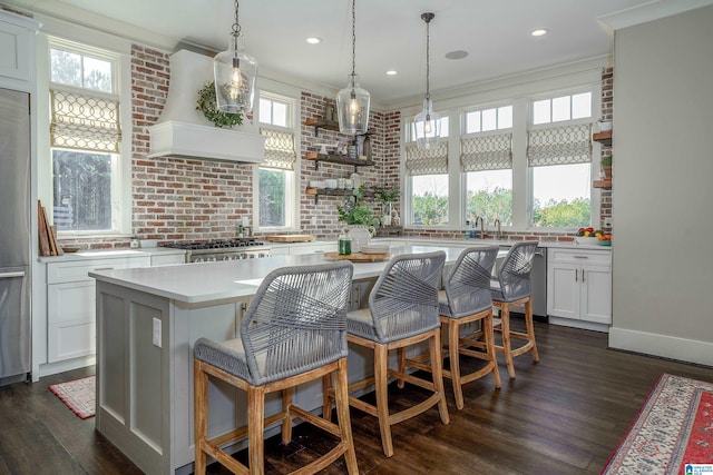 kitchen featuring a kitchen breakfast bar, white cabinetry, dark hardwood / wood-style flooring, and a center island