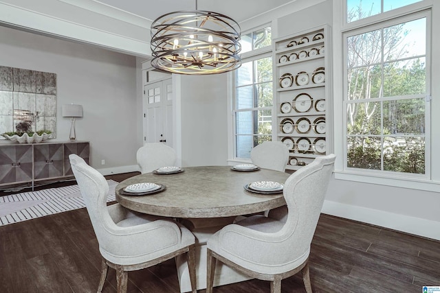 dining room featuring dark wood-type flooring, built in features, and a chandelier