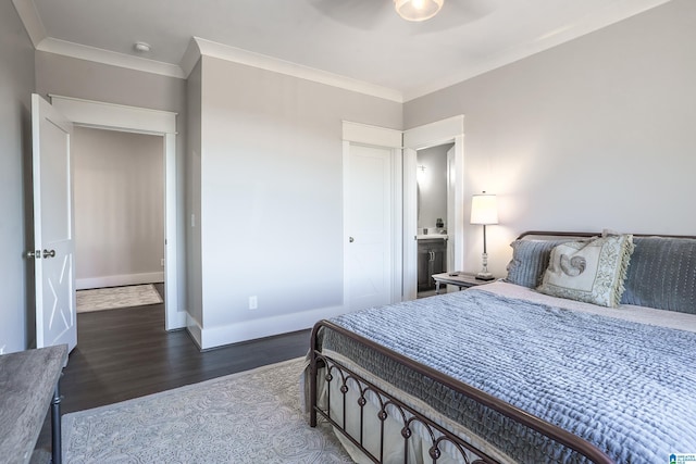 bedroom with ensuite bath, ceiling fan, ornamental molding, and dark wood-type flooring