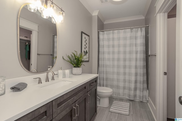 bathroom featuring toilet, vanity, tile patterned flooring, and crown molding