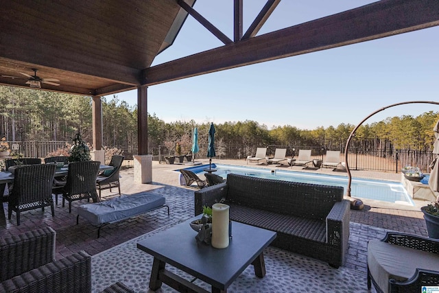 view of patio / terrace with an outdoor living space, ceiling fan, and a fenced in pool