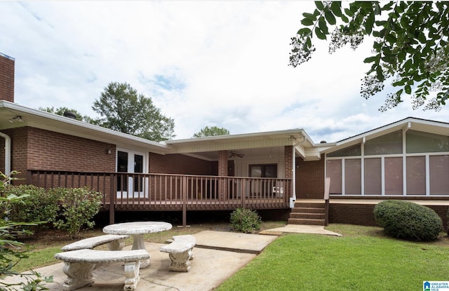 rear view of property with a patio area, a deck, a yard, and french doors