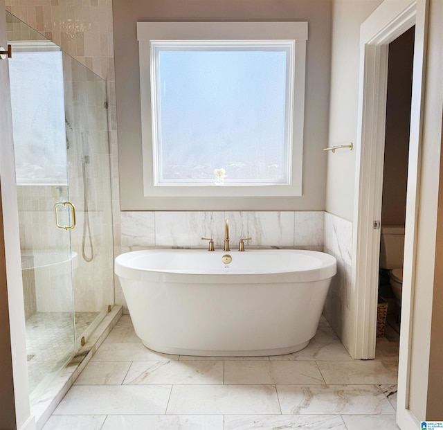 bathroom featuring toilet, a wealth of natural light, and plus walk in shower