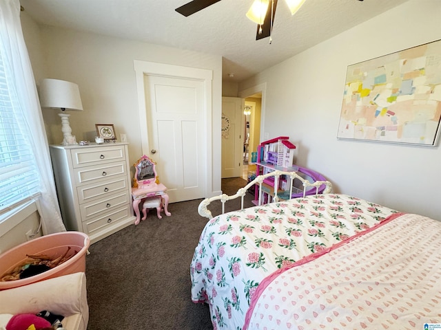 carpeted bedroom with ceiling fan and a textured ceiling