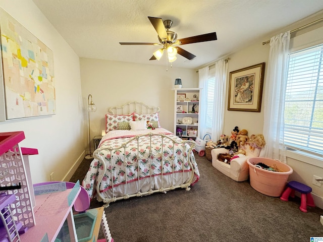 carpeted bedroom with ceiling fan, multiple windows, and a textured ceiling