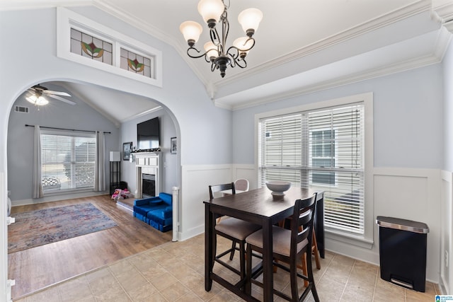 dining space featuring ceiling fan with notable chandelier, light tile patterned floors, lofted ceiling, and a wealth of natural light