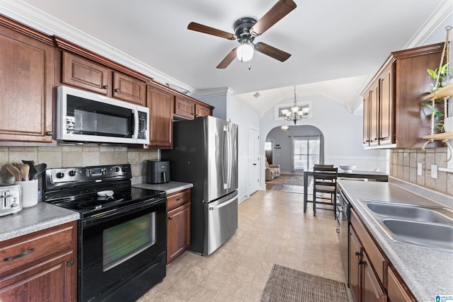 kitchen with backsplash, vaulted ceiling, crown molding, and appliances with stainless steel finishes