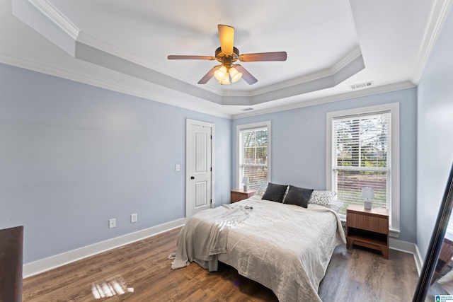 bedroom with crown molding, multiple windows, ceiling fan, and a raised ceiling