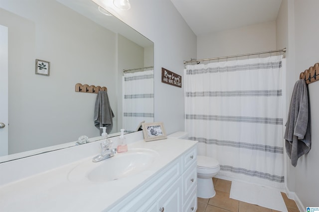 bathroom with tile patterned flooring, vanity, toilet, and walk in shower