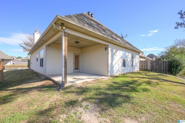 back of property featuring a lawn and a patio