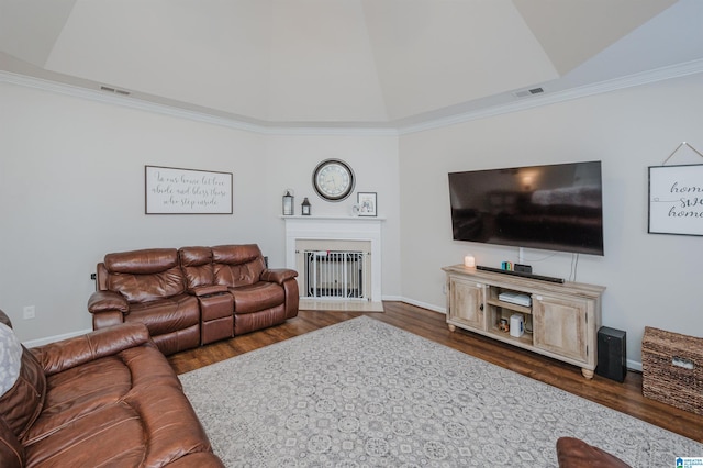 living room featuring dark hardwood / wood-style floors, crown molding, and a tray ceiling