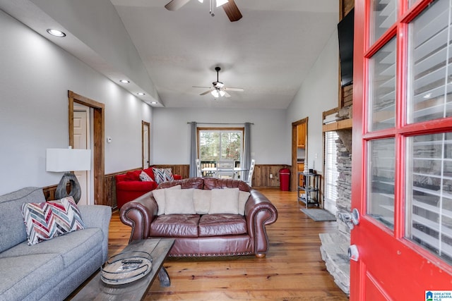 living room featuring light hardwood / wood-style floors, ceiling fan, and lofted ceiling