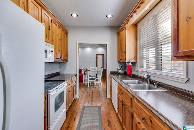 kitchen featuring white appliances, sink, and light hardwood / wood-style flooring