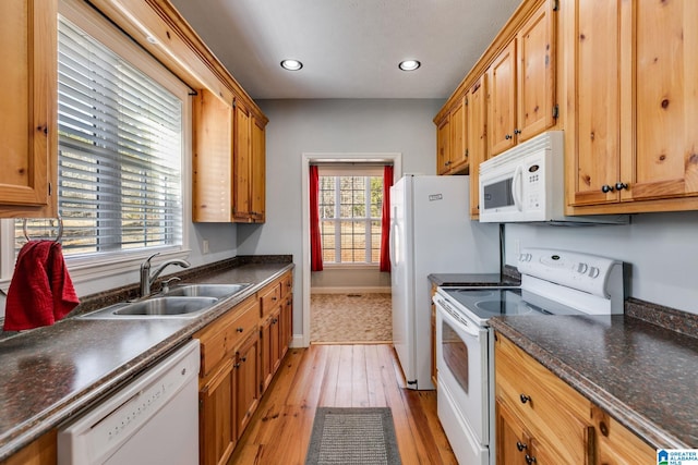 kitchen featuring sink, white appliances, and light wood-type flooring