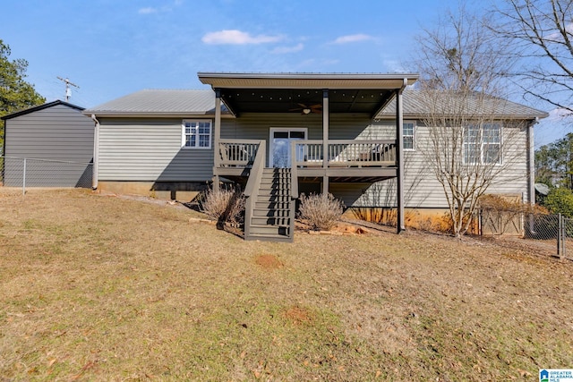 rear view of property featuring a yard, a deck, and ceiling fan