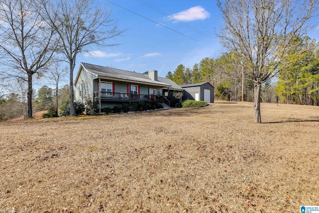 view of front facade with an outbuilding, a garage, and a front lawn