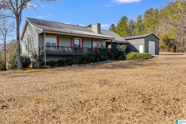 view of front facade featuring an outdoor structure, a front yard, and a garage