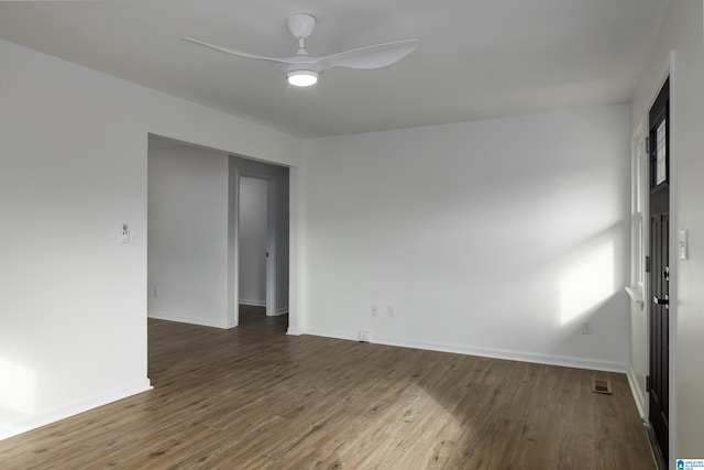 empty room with dark hardwood / wood-style flooring and ceiling fan